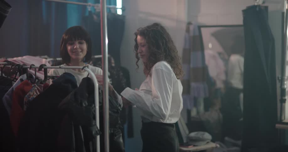 A woman helps a teenager try on a jacket