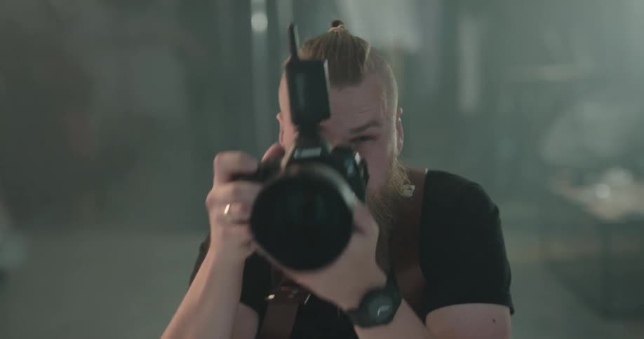 A man is taking photographs with a camera indoors