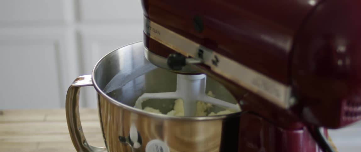 A purple mixer mixes dough