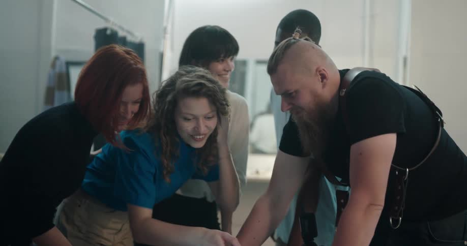 People look through pictures on camera before inviting two others over to also look
