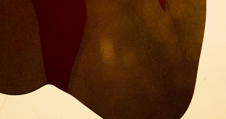Abstract footage of liquid paint flowing on a cream background