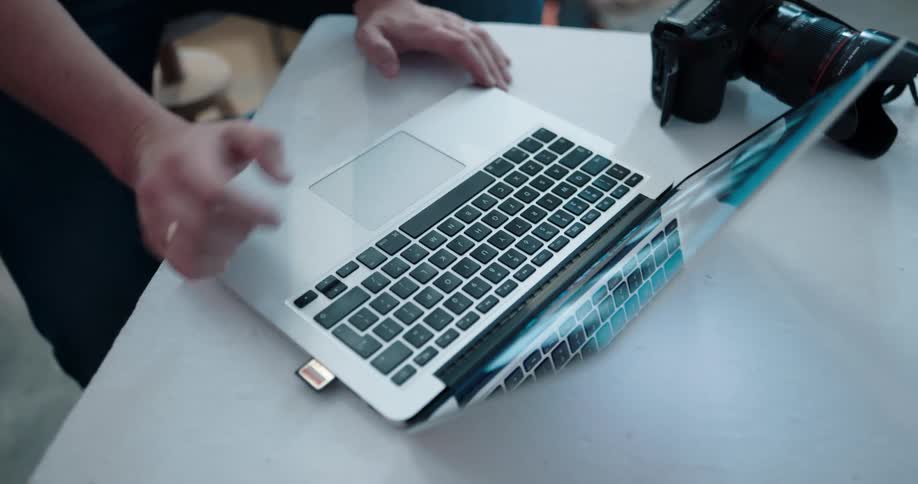 A person is plugging his camera into a laptop