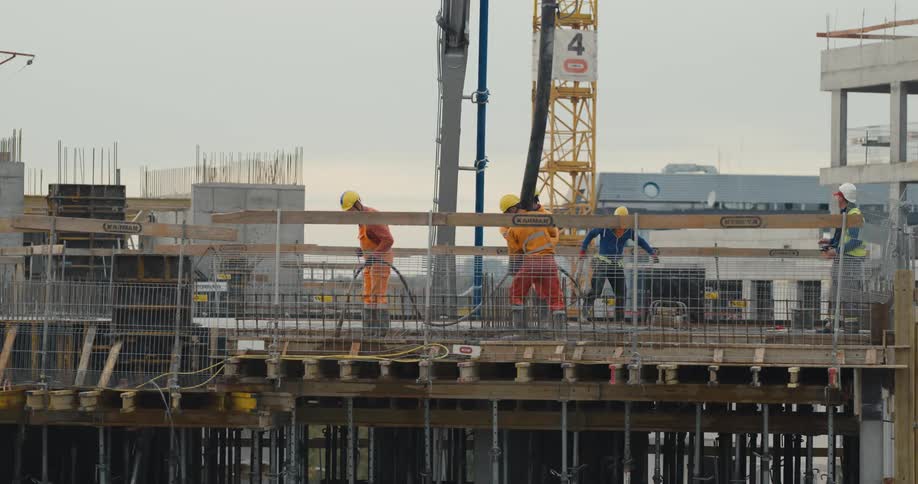 A group of construction workers are working outdoors at dusk
