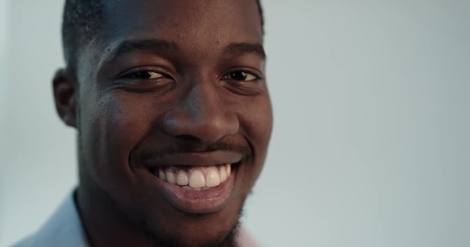 Closeup of handsome black man turning to look at camera and smiling