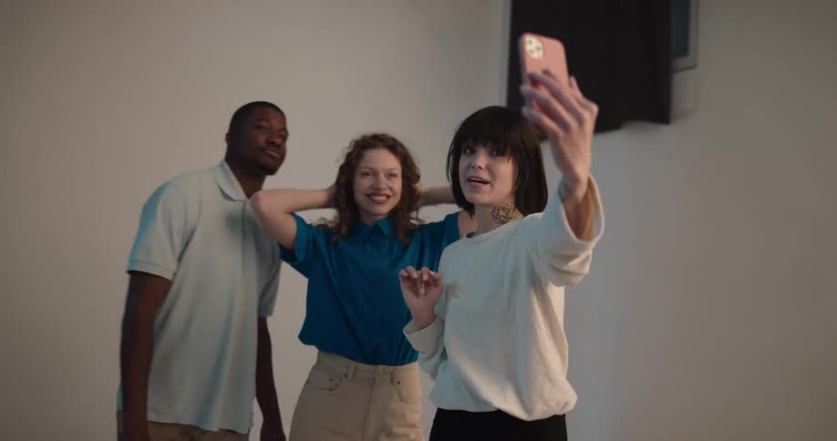 Three friends are taking selfies together indoors