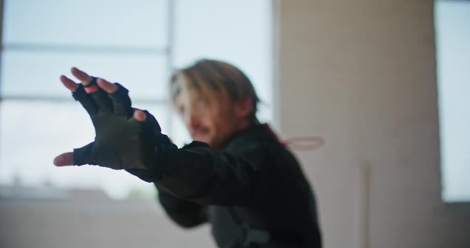 A man wearing interactive computer virtual reality devices is doing martial arts movements