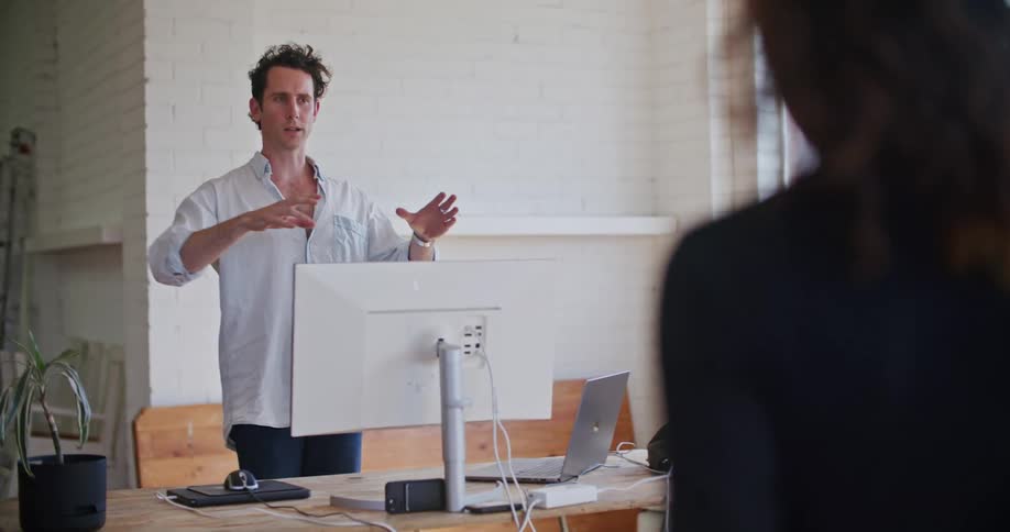 Two colleagues chat in a warehouse studio