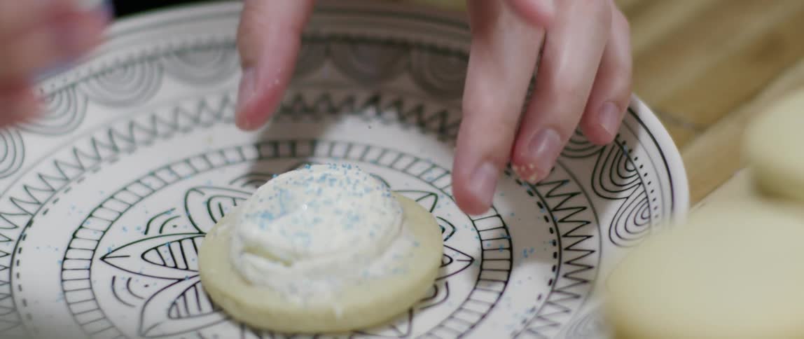 A person picks a cookie up from a plate