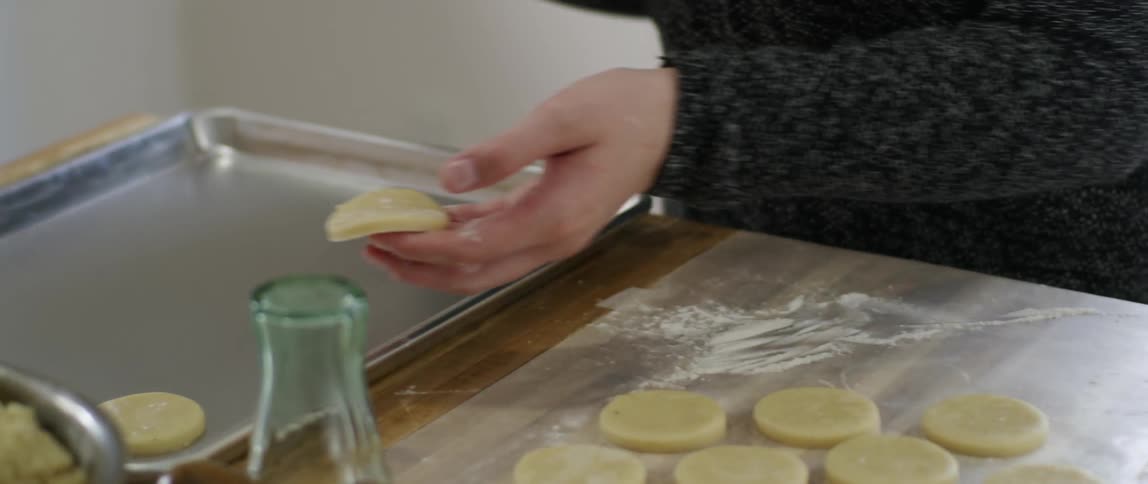 Woman placing cookie dough onto a cookie sheet