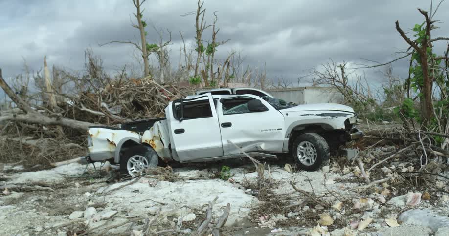 A smashed up truck on the shore