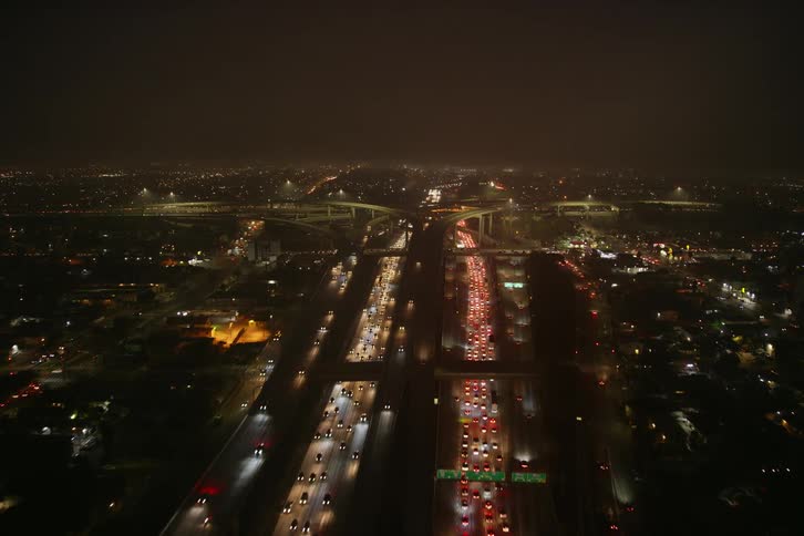 Aerial of commuters in traffic on a freeway in the city at night