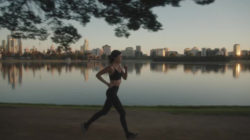 A woman jogs along the oceanfront across from downtown