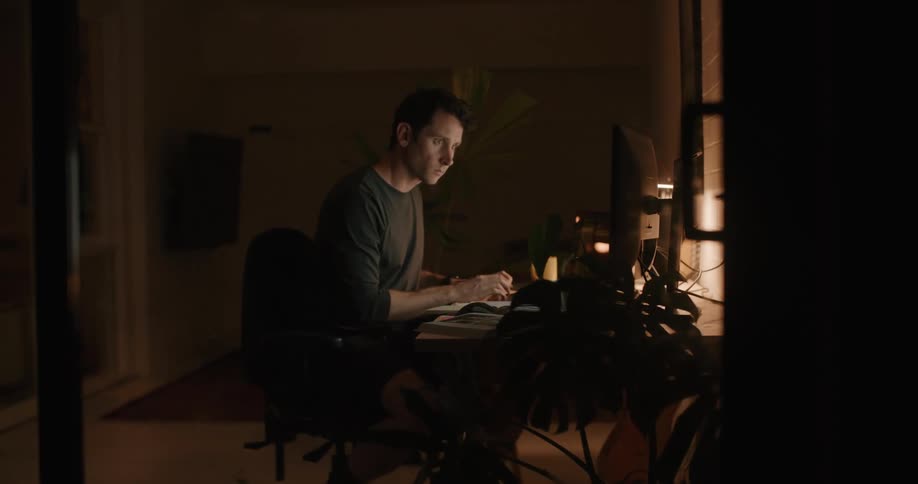 A man slides over to his desk to type