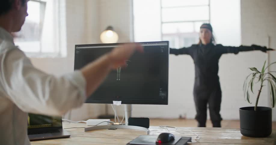 Man working with woman wearing a motion capture suit directs her motions