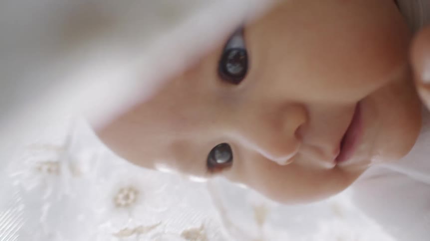A baby smiles as he lies down at home