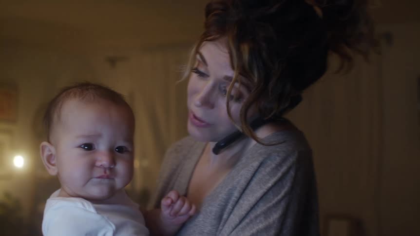 A woman tries to calm down her son while talking on the phone