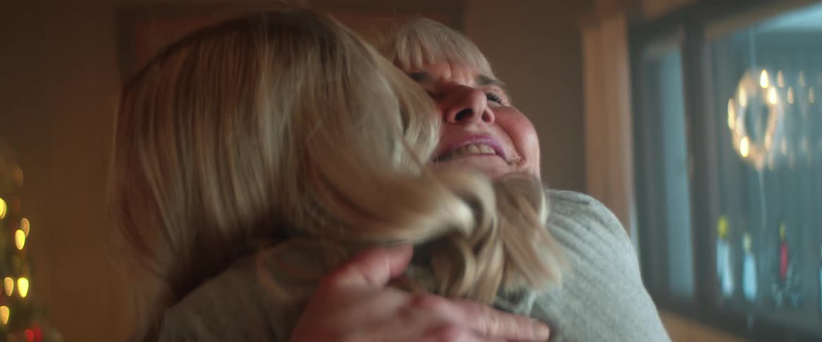 Two women are smiling and hugging each other