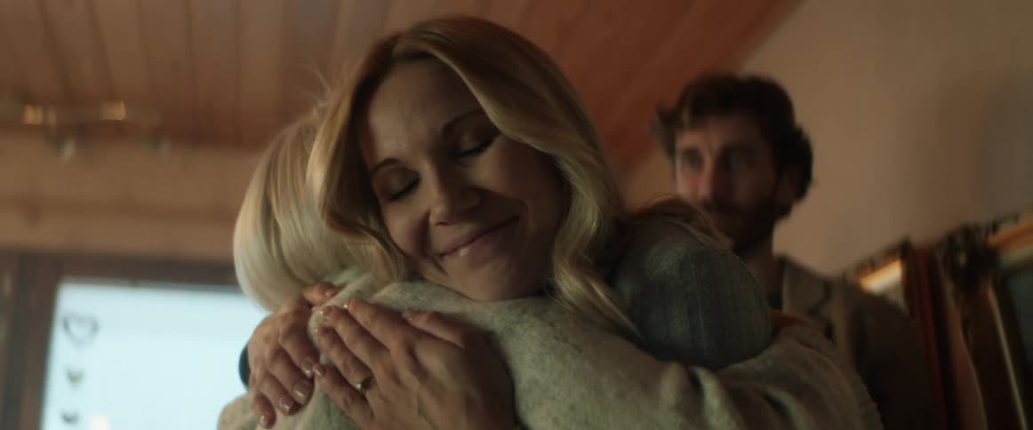 Two women hug and greet each other