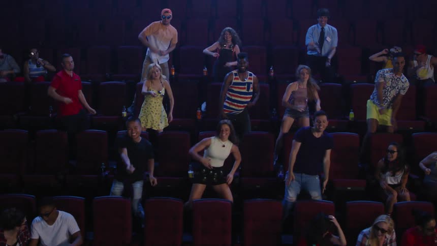 A group of people are dancing in a theater