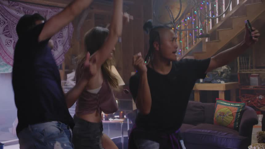Three young friends record themselves dancing and partying on a smartphone