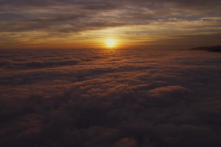 Sunlight above the clouds at a distance during sunset