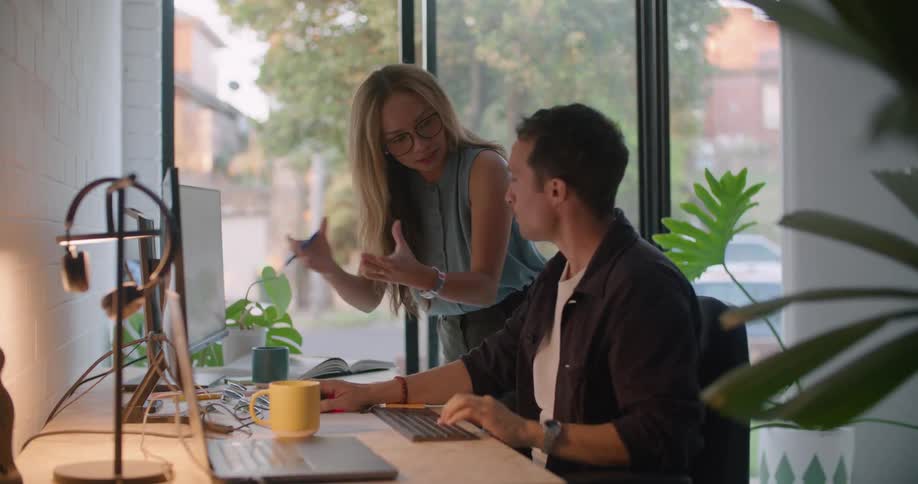 Male and female coworkers work on computers in the office