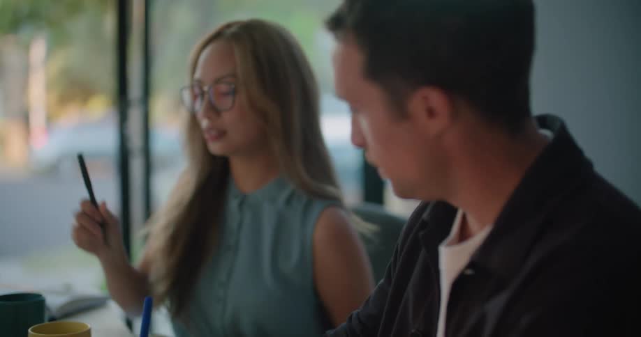 Woman and man sitting at the office desk taking notes about a sunglasses