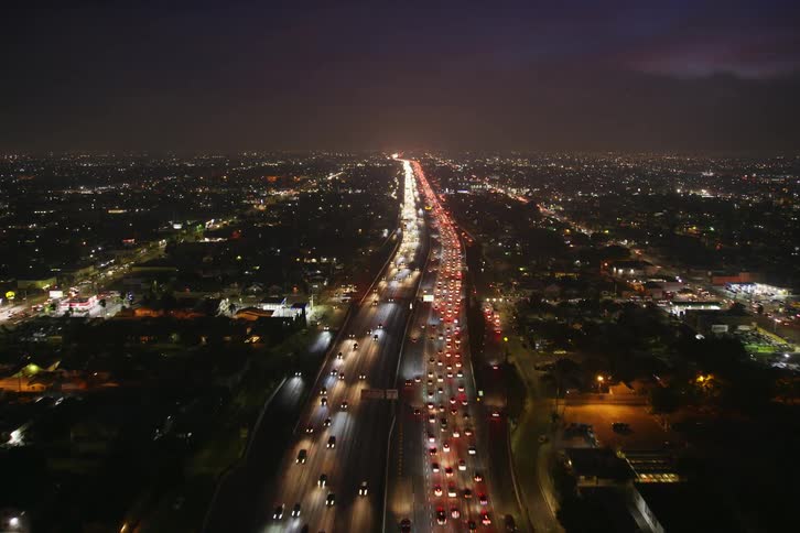 Heavy traffic passes through downtown and lights up the city at night