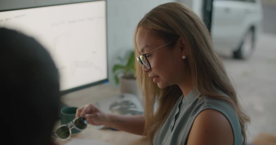 Two coworkers looking at glasses