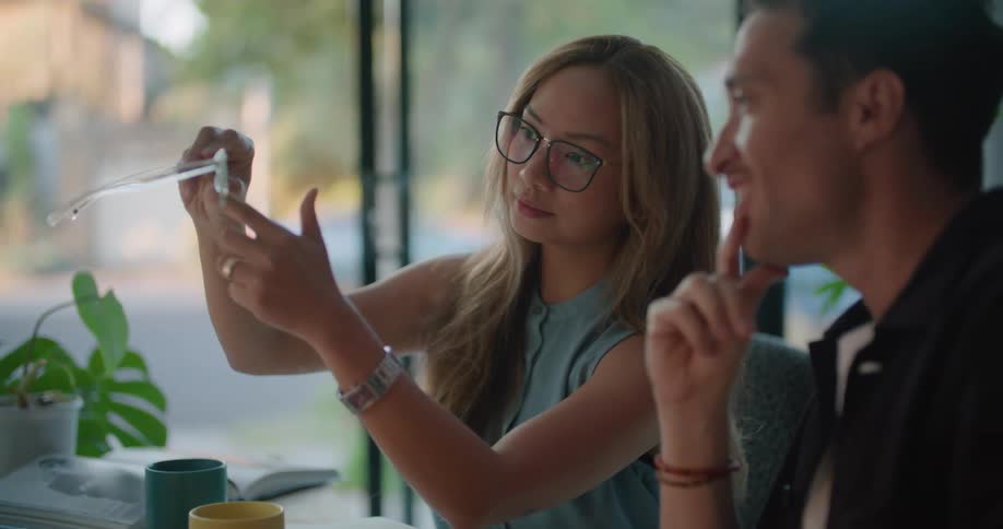 Two people examine sunglasses at the desk