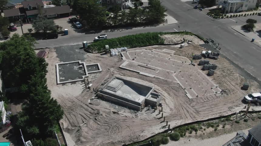 Aerial drone shot of a construction site while cars are driving by