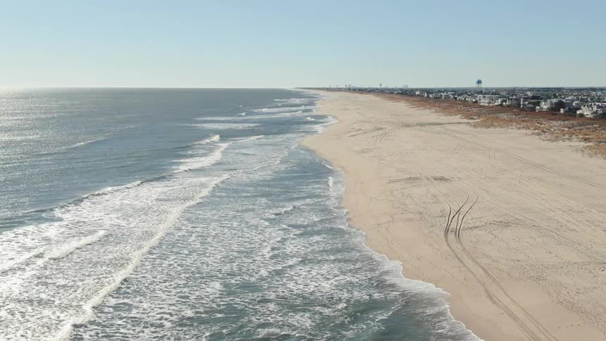 Aerial panoramic view of coastal long shoreline stretch near waterfront homes