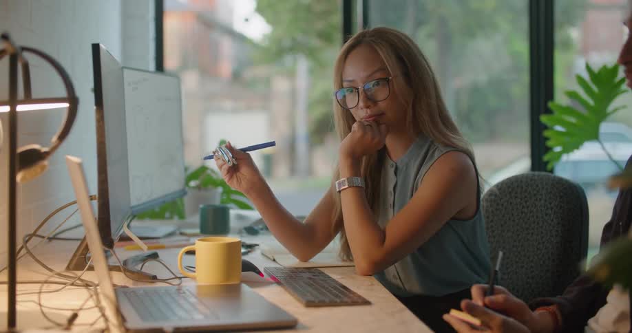Coworkers discuss shades with someone via video conference on a computer