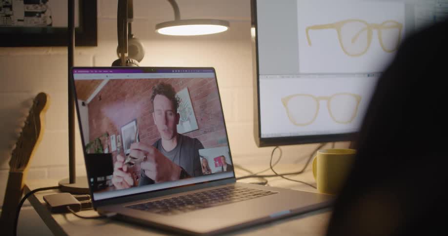 Three coworkers on a video call on a laptop talking about the sunglasses theyre designing