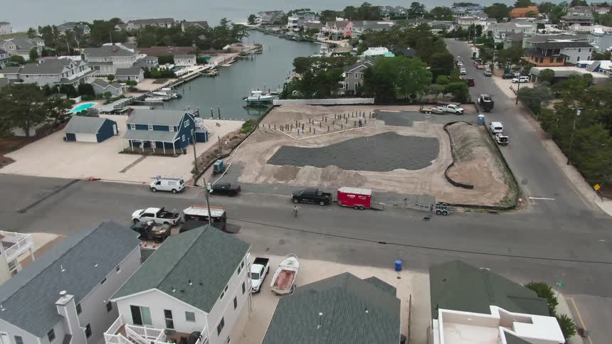 Coastal homes sit in blocks along the ocean near a construction site