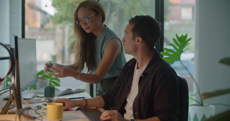 Two people are working by a desktop