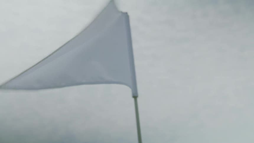 The pin flag blows in the wind