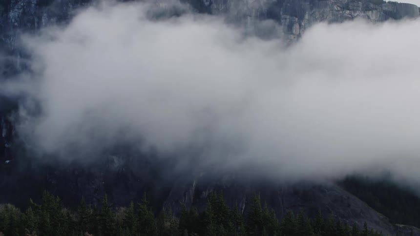 Fog roles across a mountain in British Colombia , Canada.