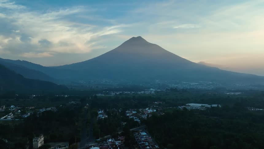 The neighborhoods of the city sit at the base of a mountain on a sunny day