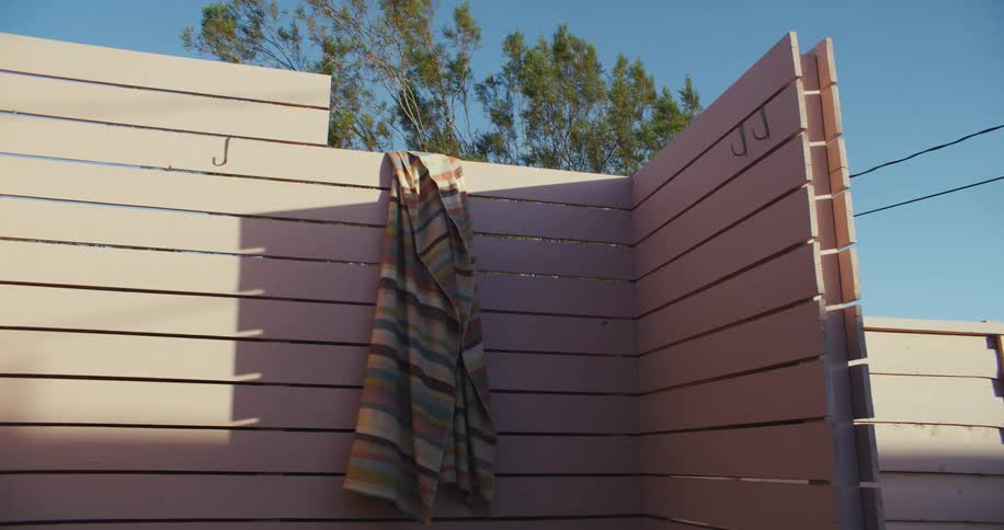 Striped fabric hangs on wooden fence on windy day