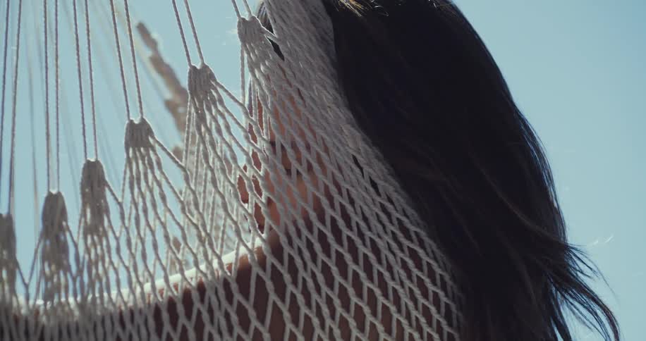 A woman is relaxing on a hammock