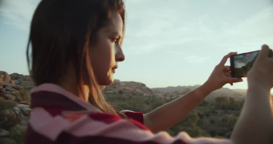 A woman is taking pictures of the desert