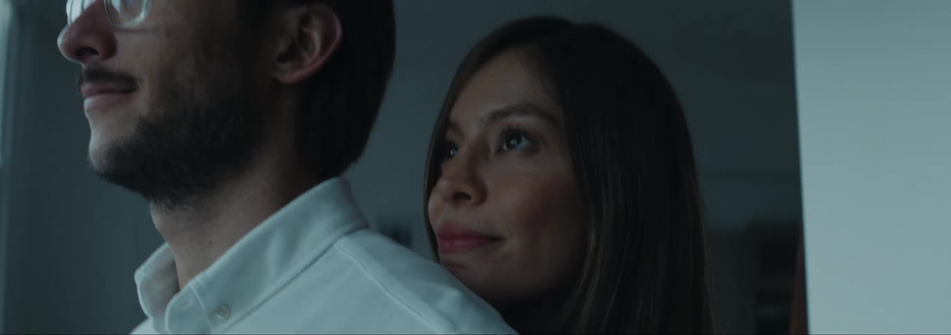 Woman hugging her husband from behind inside the house