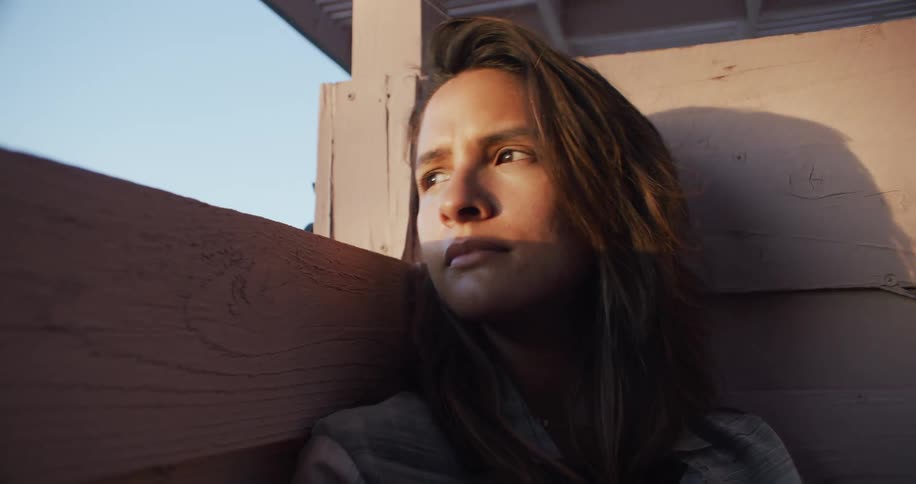 A woman is leaning against the wall resting