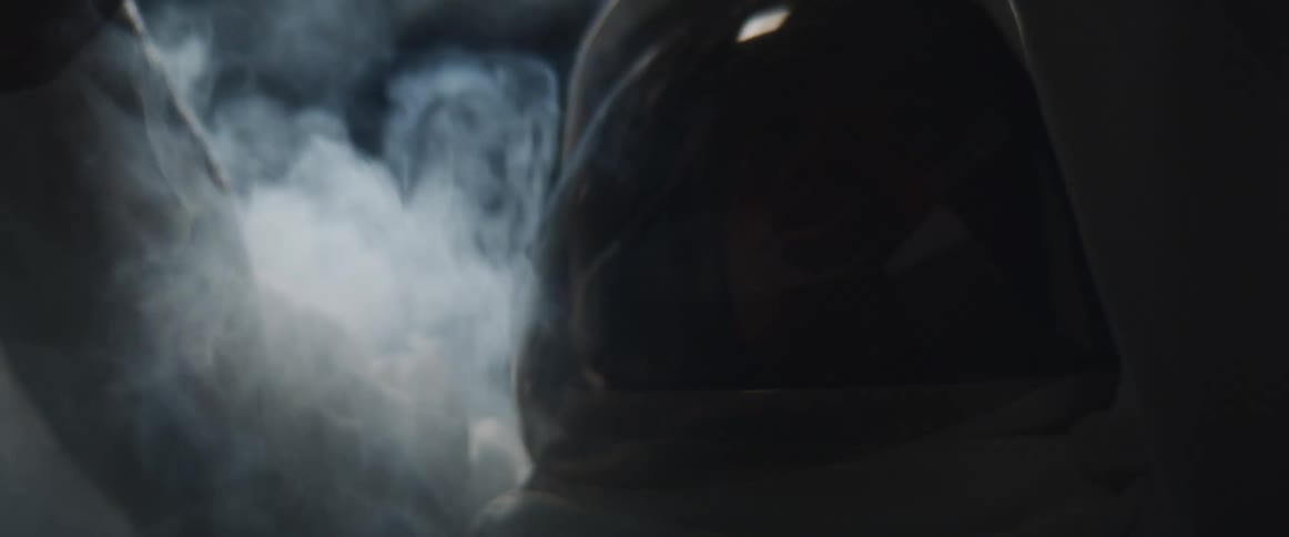 An astronaut stands in a room filling with heavy smoke