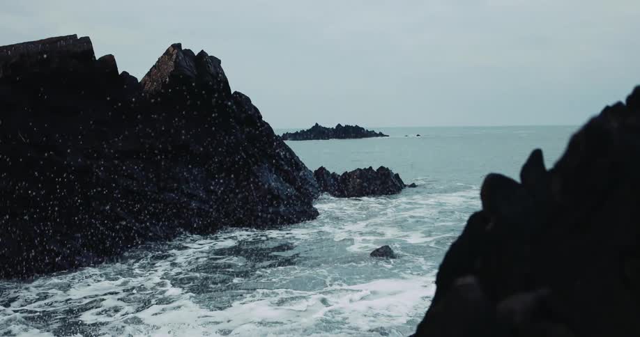 Foamy ocean waves crash against oceanside cliff