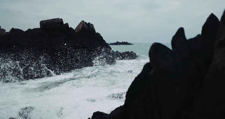 Agitated waves hitting the rocks at the coast