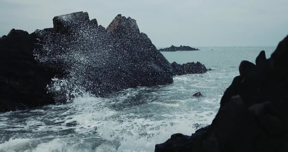 Waves hitting the rocks at the coast during daytime