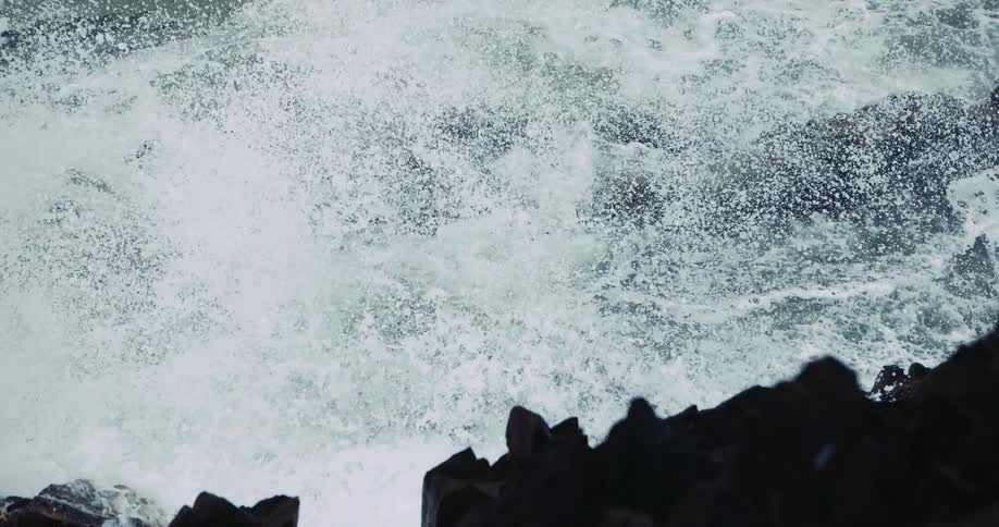 Foamy ocean waves break against oceanside cliff