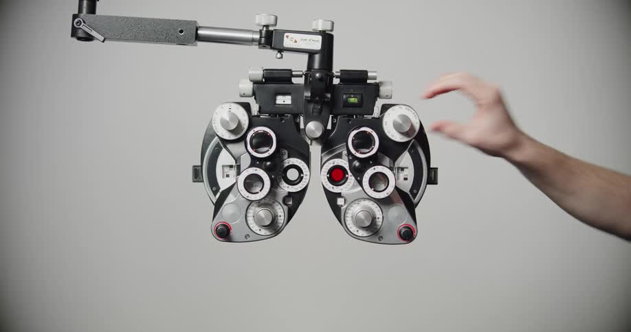 A person adjusts the knob on the phoropter